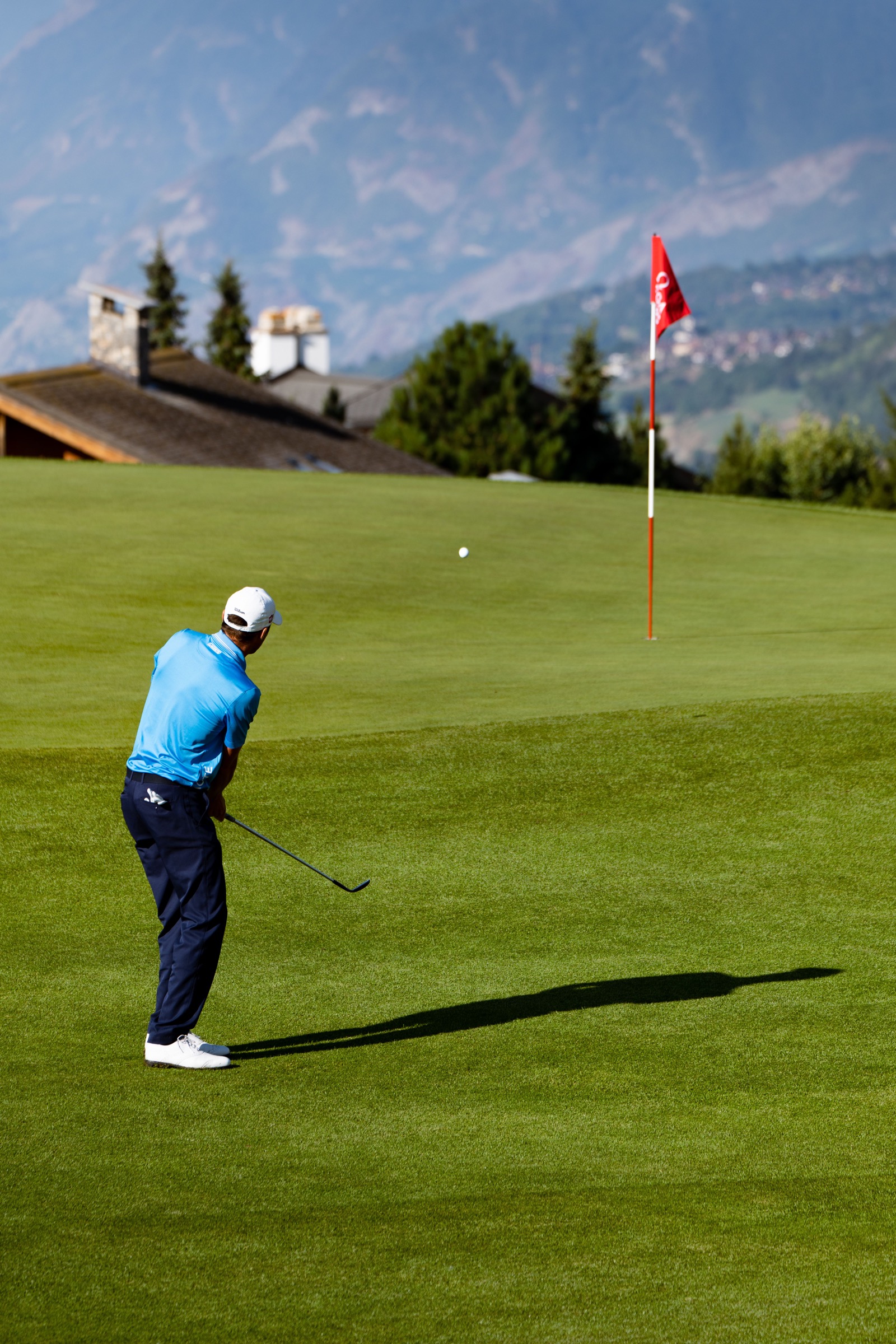 Golfer walking a pristine fairway at golden hour
